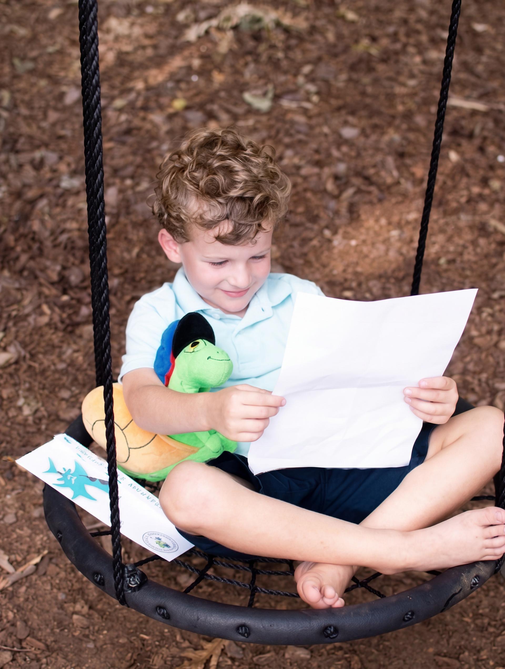 A child reading a Sunny letter on a swing with his plush snail
